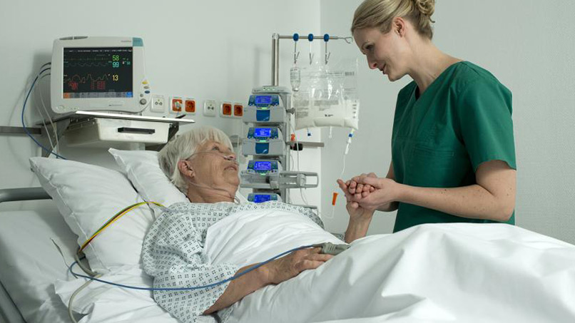 Idosa hospitalizada conversando com a enfermeira
